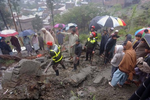 Petugas penyelamat dan penduduk setempat berkumpul untuk membersihkan puing-puing rumah yang sebagian rusak akibat tanah longsor akibat hujan lebat di Matta, sebuah kota di Lembah Swat, Pakistan, Minggu, (14/4/2024) Foto: Rescue 1122 Emergency Department via AP