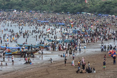 Wisatawan memadati pantai Pangandaran di Kabupaten Pangandaran, Jawa Barat, Selasa (16/4/2024). Foto: Adeng Bustomi/Antara Foto