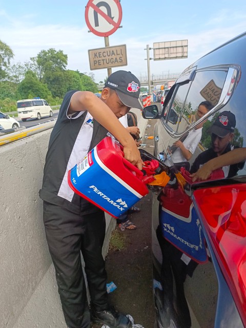 Tim motorist Pertamina saat mengisi BBM ke mobil yang mogok di ruas tol arah Jakarta. Foto: Dok. Pertamina