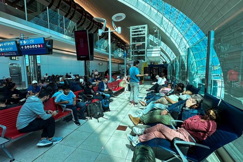 Penumpang mengantri di meja koneksi penerbangan di Bandara Internasional Dubai di Dubai (17/4/2024) Foto: AFP