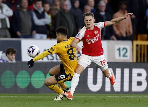 Leandro Trossard berduel dengan Joao Gomes saat Wolves vs Arsenal dalam laga pekan ke-33 Liga Inggris 2023/24 di Stadion Molineaux pada Minggu (21/4) dini hari WIB. Foto: Action Images via Reuters/Jason Cairnduff