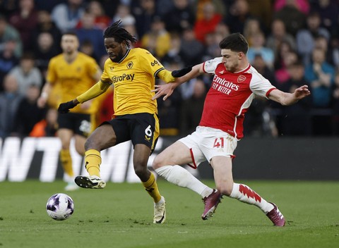 Boubacar Traore berduel dengan Declan Rice saat Wolves vs Arsenal dalam laga pekan ke-33 Liga Inggris 2023/24 di Stadion Molineaux pada Minggu (21/4) dini hari WIB. Foto: Action Images via Reuters/Jason Cairnduff