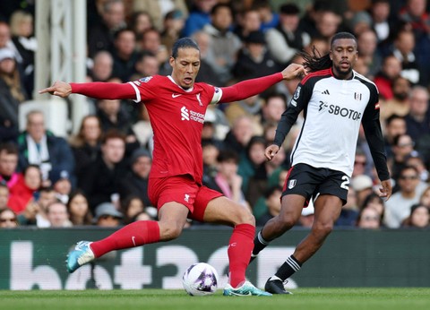 Virgil van Dijk dari Liverpool beraksi bersama Alex Iwobi dari Fulham  Foto: Isabel Infantes/REUTERS