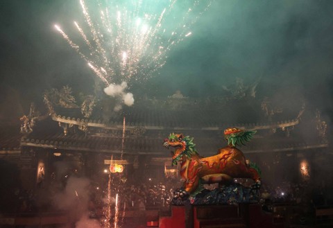 Kembang api singa api dinyalakan di kuil Dalongdong Baoan untuk merayakan ulang tahun Baosheng Dadi (diet pengobatan) selama festival budaya Baosheng di Taipei (22/4/2024) Foto: I-HWA CHENG / AFP