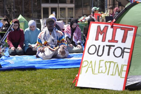 Mahasiswa Institut Teknologi Massachusetts Isa Liggans, dari Odenton, Md., kiri depan, ikut serta dalam doa Muslim bersama yang lain Senin, 22 April 2024, di tenda perkemahan di MIT, di Cambridge, Mass. Foto: AP/Steven Senne