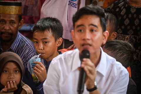 Seorang anak (kiri) minum susu gratis saat Wapres terpilih Gibran Rakabuming Raka (kanan) menyapa warga di Rusun Muara Baru, Jakarta Utara, Rabu, (24/4/2024). Foto: Erlangga Bregas Prakoso/ANTARA FOTO