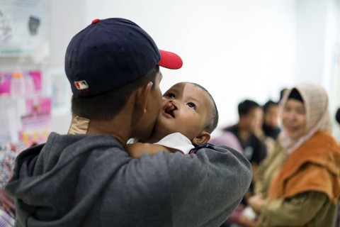 Persiapan Oprasi: Salah satu orang tua pasien menggendong anaknya saat antre untuk operasi bibir sumbing di RSUD Tamansari Jakarta. Foto: Syawal Febrian Darisman/kumparan