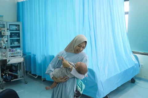 Senyum Bahagia: Orang tua pasien menggendong anaknya usai operasi bibir sumbing di RSUD Tamansari Jakarta. Foto: Syawal Febrian Darisman/kumparan