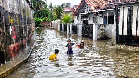 Tiga orang anak yang tengah mandi saat banjir terjadi di wilayah Puncak Sekuning Palembang, Sabtu (27/4) Foto: ary priyanto/urban id
