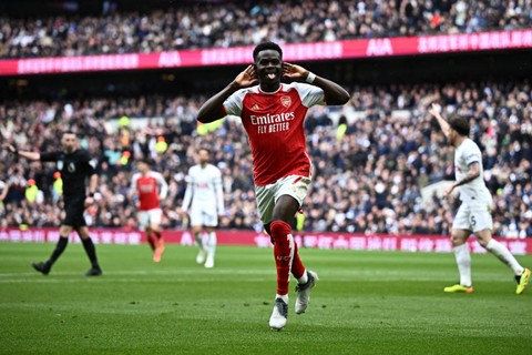 Selebrasi pemain Arsenal Bukayo Saka usai mencetak gol ke gawang Tottenham Hotspur pada pertandingan Liga Inggris di Tottenham Hotspur Stadium, London, Inggris, Minggu (28/4/2024). Foto: Dylan Martinez/ REUTERS