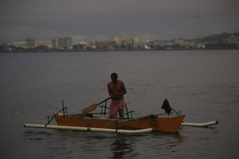 Seorang nelayan di pesisir pantai Manado tetap memilih melaut walaupun kondisi cuaca tak bersahabat. (foto: febry kodongan/manadobacirita)