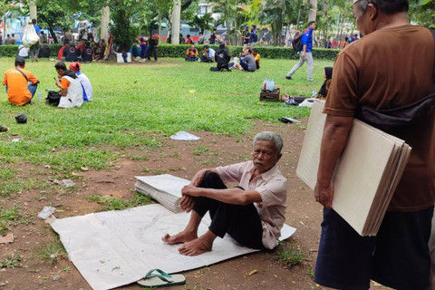 Para penjual tikar di tengah demo buruh di sekitar Patung Kuda, Jakarta Pusat, Rabu (1/5/2024). Foto: Rachmadi Rasyad/kumparan