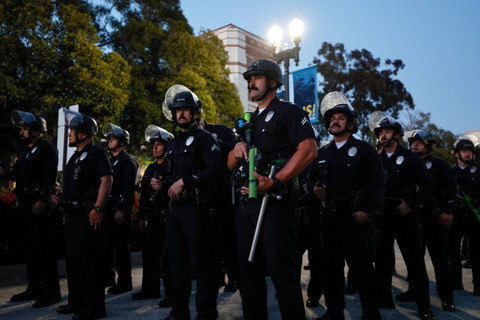 Petugas polisi mengambil posisi saat mahasiswa dan aktivis pro-Palestina berdemonstrasi di kampus Universitas California, Los Angeles (UCLA) di Los Angeles, California (1/5/2024). Foto: ETIENNE LAURENT / AFP