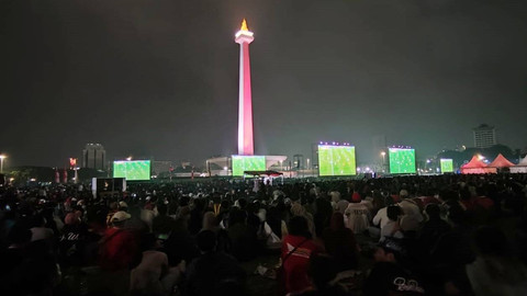Warga menyaksikan pertandingan Timnas Indonesia U-23 melawan Irak pada pertandingan perebutan tempat ketiga Piala Asia U-23 2024 di Plaza Selatan Monumen Nasional (Monas), Jakarta, Kamis (2/5/2024). Foto: Rachmadi Rasyad/kumparan