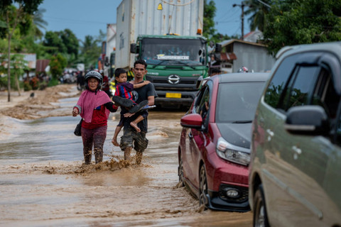 Warga menerobos banjir di Kecamatan Suli, Kabupaten Luwu, Sulawesi Selatan, Jumat (3/5/2024). Foto: Hariandi Hafid/ANTARA FOTO