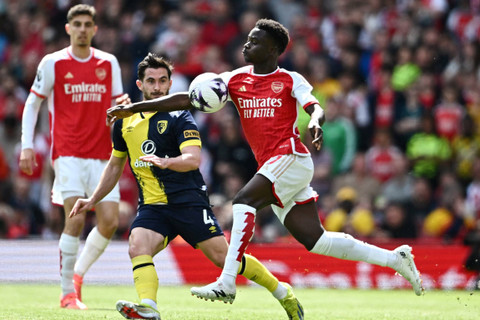 Bukayo Saka dari Arsenal beraksi dengan Lewis Cook dari AFC Bournemouth di Emirates Stadium, London, Inggris, Sabtu (4/5/2024). Foto: Dylan Martinez/REUTERS