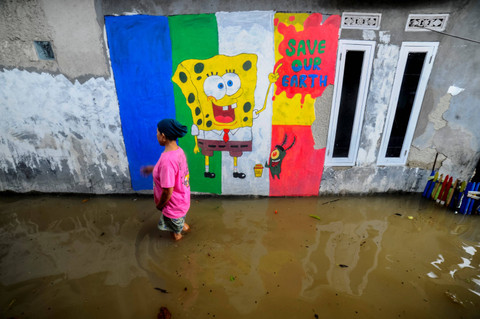 Warga berjalan menerobos air saat banjir di Desa Songgom Jaya, Cikande, Kabupaten Serang, Banten, Sabtu (4/5/2024). Foto: Muhammad Bagus Khoirunas/ANTARA FOTO