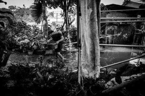 Membuang Air: Warga membuang air banjir yang merendam rumahnya di Kampung Bulak Barat, Kota Depok. Foto: Iqbal Firdaus/kumparan