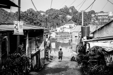 Menengok Kondisi Rumah: Warga berjalan di dekat rumah yang terendam banjir di Kampung Bulak Barat, Kota Depok Foto: Iqbal Firdaus/kumparan