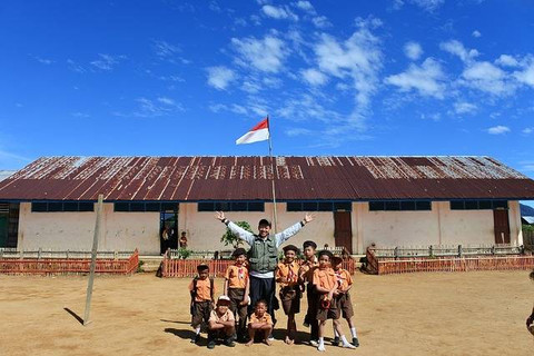 Seorang guru dan murid-muridnya sedang berpose bersama di depan sekolahnya (https://pixabay.com)