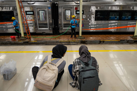 Penumpang memperhatikan pekerja yang membersihkan gerbong kereta di Stasiun Bandung, Jawa Barat, Kamis (9/5/2024). Foto: Raisan Al Farisi/ANTARA FOTO