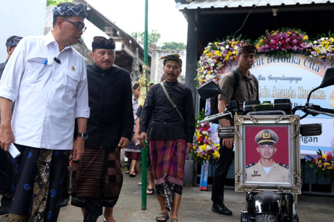 Menteri Perhubungan Budi Karya Sumadi (kiri) mengamati sebuah foto almarhum Putu Satria Ananta Rustika yang diletakan di sepeda motor saat berkunjung ke rumah duka di Desa Gunaksa, Klungkung, Bali, Kamis (9/5/2024). Foto: Nyoman Hendra Wibowo/ANTARA FOTO