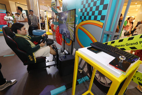 Pengunjung sedang mencoba simulator Macau Grand Prix. Foto: Dok. MGTO
