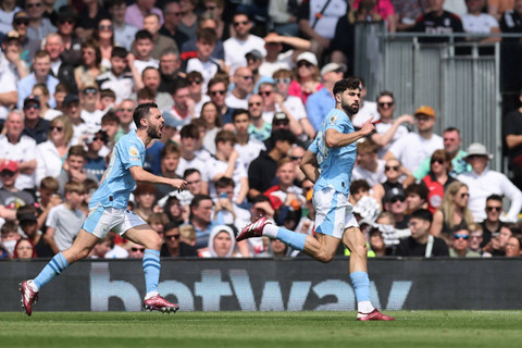 Pemain Manchester City Josko Gvardiol merayakan mencetak gol pertama mereka dengan Bernardo Silva di Craven Cottage, London, Inggris, Sabtu (11/5/2024). Foto: David Klein/Reuters