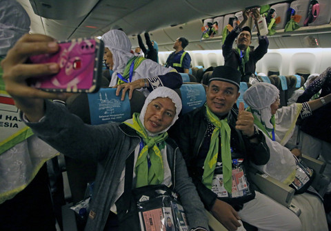 Jemaah calon haji berswafoto saat berada di dalam pesawat di Terminal 2F Bandara Soekarno Hatta, Tangerang, Banten, Minggu (12/5/2024).  Foto: Muhammad Iqbal/ANTARA FOTO