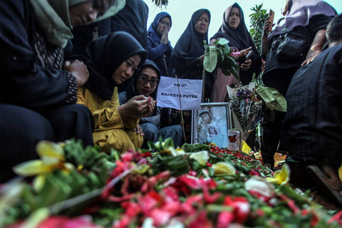 Sejumlah keluarga dan kerabat berdoa di depan makam korban kecelakaan bus rombongan SMK Lingga Kencana Depok, di TPU Parung Bingung, Depok, Jawa Barat, Minggu (12/5/2024). Foto: Yulius Satria Wijaya/ANTARA FOTO