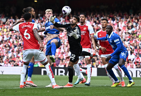 David Raya dari Arsenal beraksi bersama Dominic Calvert-Lewin dari Everton dan Jarrad Branthwaite.  Foto: Dylan Martinez/REUTERS