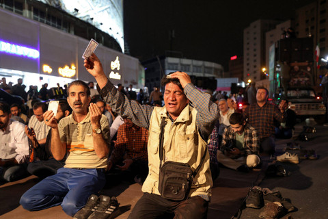 Warga Iran berdoa atas insiden kecelakaan helikopter yang membawa Presiden Ebrahim Raisi dan Menteri Luar Negeri Hossein Amir-Abdollahian di Lapangan Valiasr, Teheran, Iran, Minggu (19/5/2024). Foto: Atta Kenare/AFP