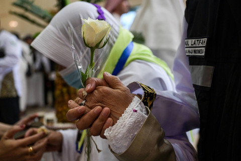 Jemaah calon haji Indonesia memegang bunga dan tangan Petugas Penyelenggara Ibadah Haji (PPIH) saat tiba di hotel, Makkah, Arab Saudi, Senin (20/5/2024). Foto: Sigid Kurniawan / ANTARA FOTO