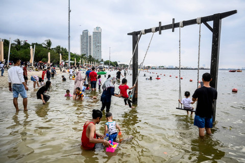 Warga bermain Donat Sport saat libur Waisak di Pantai Ancol, Jakarta, Kamis (23/5/2024). Foto: Rivan Awal Lingga/ANTARA FOTO