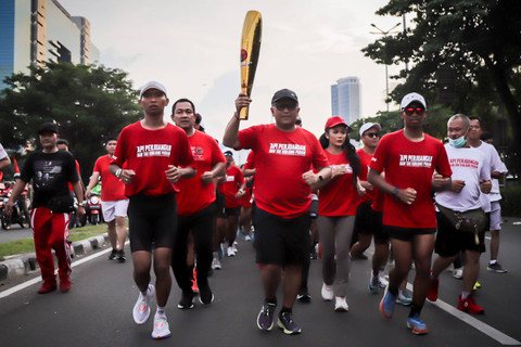 Sekjen PDIP Hasto Kristiyanto berlari sambil memegang obor bersama rombongan pembawa 'Obor Api Perjuangan' di Kemayoran, Jakarta, Kamis (23/5/2024). Foto: Jamal Ramadhan/kumparan