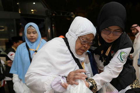 Petugas Penyelenggara Ibadah Haji Daker Makkah membantu jemaah calon haji Indonesia embarkasi Solo SOC 43 setibanya di hotel, Makkah, Arab Saudi, Sabtu (25/5/2024). Foto: Sigid Kurniawan/Antara Foto