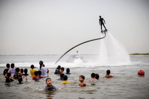Pengunjung berwisata di Pantai Lagoon Ancol, Jakarta, Sabtu (25/5/2024). Foto: Jamal Ramadhan/kumparan