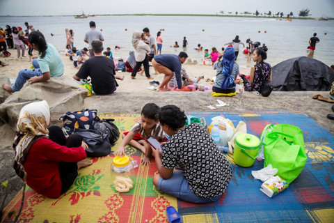 Pengunjung berwisata di Pantai Lagoon Ancol, Jakarta, Sabtu (25/5/2024). Foto: Jamal Ramadhan/kumparan