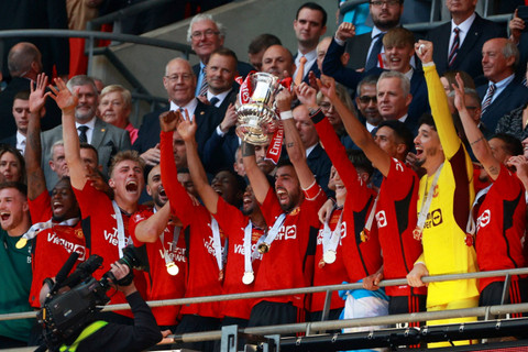 Pemain Manchester United Bruno Fernandes mengangkat trofi saat ia merayakan bersama rekan satu timnya setelah memenangkan Piala FA di Stadion Wembley, London, Inggris, Sabtu (15/5/2024). Foto: Action Images via Reuters/Andrew Couldridge