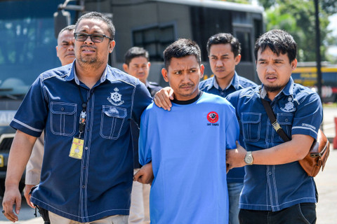Petugas Kepolisian menggiring tersangka kasus pembunuhan Pegi Setiawan untuk dihadirkan pada konferensi pers yang digelar di Gedung Ditreskrimum Polda Jabar, Bandung, Jawa Barat, Minggu (26/5/2024). Foto: Raisan Al Farisi/ANTARA FOTO