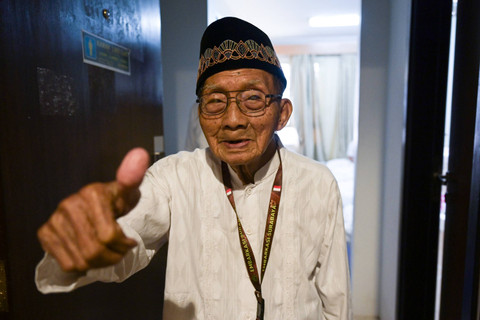 Jemaah haji Indonesia embarkasi Surabaya SUB 19, Harjo Mislan, mengacungkan jempol kepada Petugas Penyelenggara Ibadah Haji di depan kamar hotelnya di Makkah, Arab Saudi, Minggu (26/5/2024).  Foto: Sigid Kurniawan / ANTARA FOTO