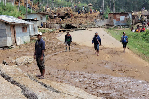 Penduduk setempat terlihat di dekat lokasi tanah longsor di desa Mulitaka di wilayah Maip Mulitaka, di Provinsi Enga, Papua Nugini (26/5/2024). Foto: AFP