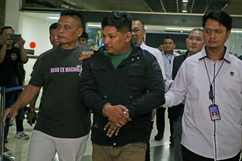 Petugas kepolisian menggiring tersangka Sofyan yang diduga sebagai bandar besar narkoba setibanya dari Medan di Terminal 2 Bandara Soekarno Hatta, Tangerang, Banten, Senin (27/5/2024). Foto: Muhammad Iqbal/ANTARA FOTO