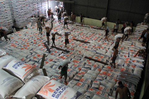 Sejumlah pekerja memikul karung beras di Gudang Bulog, Medan, Sumatera Utara, Selasa (28/5/2024). Foto: Yudi Manar / ANTARA FOTO