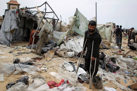 Seorang warga Palestina memeriksa tenda pengungsian yang rusak akibat serangan Israel selama operasi militer Israel, di Rafah, di selatan Jalur Gaza (28/5/2024). Foto: Hatem Khaled/REUTERS