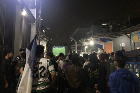 Warga Jalan Babakan Irigasi, Kelurahan Babakan Tarogong, Kecamatan Bojongloa Kaler tutup jalan demi gelar nobar laga final Persib Bandung vs Madura United, Jumat (31/5/2024). Foto: Robby Bouceu/kumparan