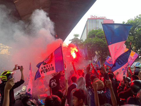 Suporter Persib Bandung tampak tumpah ruah ke jalan sambil menunggu arak-arakan pemain Persib setelah berhasil juara liga 1, Sabtu (1/6). Foto: Robby Bouceu/kumparan