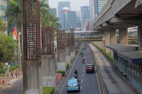 Sejumlah kendaraan melintas di antara tiang monorel yang terhenti pembangunannya di Jalan Rasuna Said,Jakarta, Jumat (31/5/2024). Foto:  Reno Esnir /ANTARA FOTO