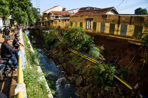 Warga melihat tebing pembatas sungai yang terdampak jebolnya pipa milik PDAM Tirtawening di Cibangkong, Bandung, Jawa Barat, Kamis (6/6/2024). Foto: Novrian Arbi/ANTARA FOTO