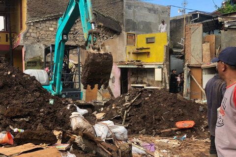 Suasana pengerukan puing rumah warga yang roboh akibat jebolnya pipa PDAM Tirtawening di Maleer, Batununggal, Bandung, pada Kamis (6/6/2024). Foto: Robby Bouceu/kumparan